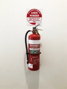 Supreme Fire Solutions close up of a fire extinguisher on the wall.